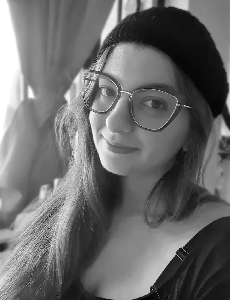 Retrato en blanco y negro de Evally Aguila, con lentes y gorro